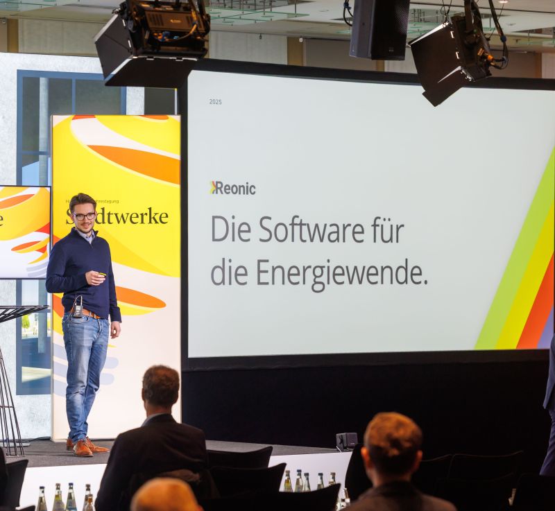 Lars-Manuel Schneider presenting on stage at the Stadtwerke conference